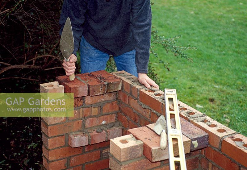 Building a barbeque. Step 8 of 11. Continue building a further three courses of bricks. Add a further supporting layer of bricks for the grill
