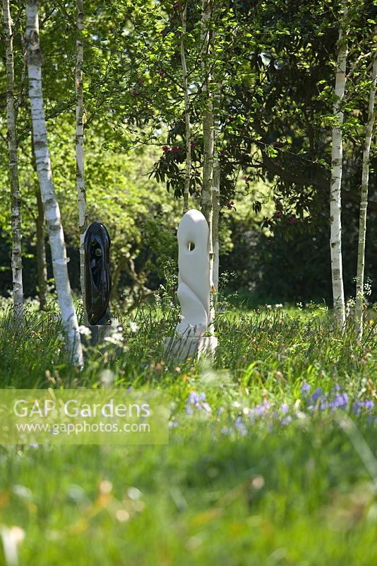 Modern sculpture designed by Mark Humphrey underneath Betula - Birch trees in meadow at Hatfield House garden, May 2008, UK