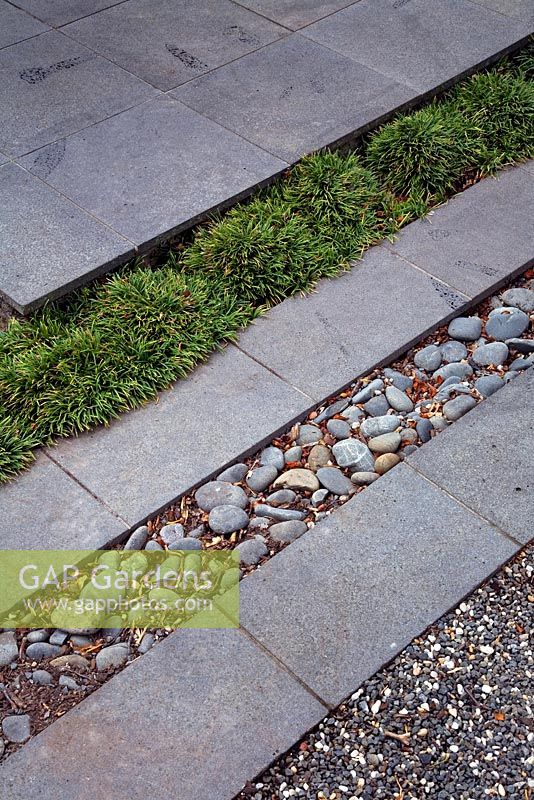 Modern surfaces of, Bluestone paving, Ophiopogon japonicum 'Nana' - Mondo grass, more Bluestone, rounded pebbles, Bluestone and grey gravel.