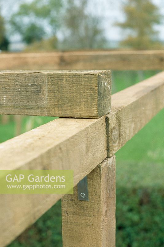 Making a pergola - Fix verticals to horizontals on the ground first, then verticals to cross pieces, then meta posts can be tightened up. Attach cross pieces using U shaped brackets, secured with galvanised nails 