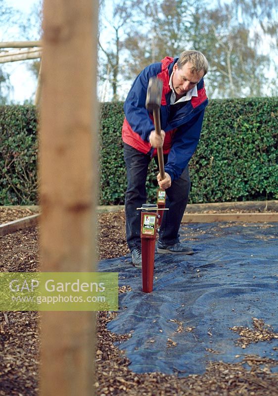 Making a pergola - Once the centre of each hole has been located, position the metal spikes. Care should be taken when positioning these, as the posts can twist in the soil