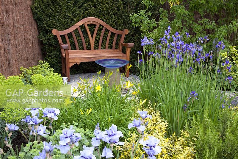Garden seat, water feature and blue Irises in the 'Dyslexia - A Barrier to Education' garden - Bronze medal winner at RHS Chelsea Flower Show 2010