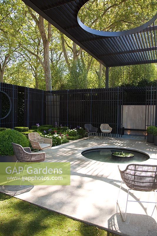 Patio with circular pool under canopy. The Cancer Research UK Garden, Gold Medal Winner RHS Chelsea Flower Show 2010