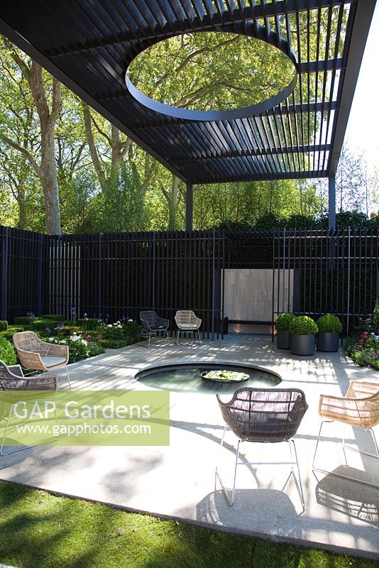 Patio with circular pool under canopy. The Cancer Research UK Garden, Gold Medal Winner RHS Chelsea Flower Show 2010