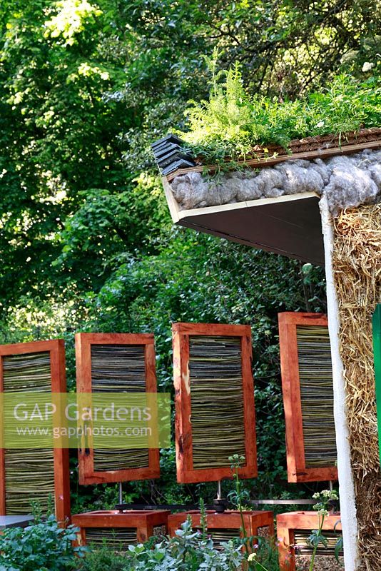 Building showing roof insulation and motorised, woven willow windbreak panels behind. The SAC Strutt and Parker Sustainable Highland Garden, Silver Medal Winner, RHS Chelsea Flower Show 2010 
 
