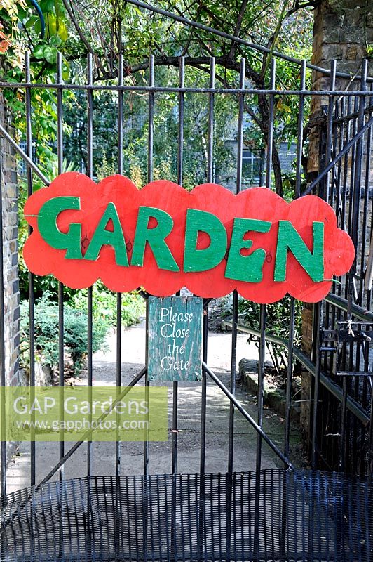 Colourful wooden sign on gate leading to garden at Hackney City Farm, London, England