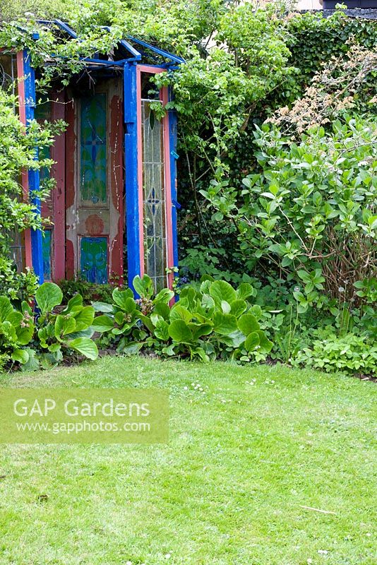 Colourful wooden gazebo in border alongside lawn. Chauffeurs Flat, Surrey