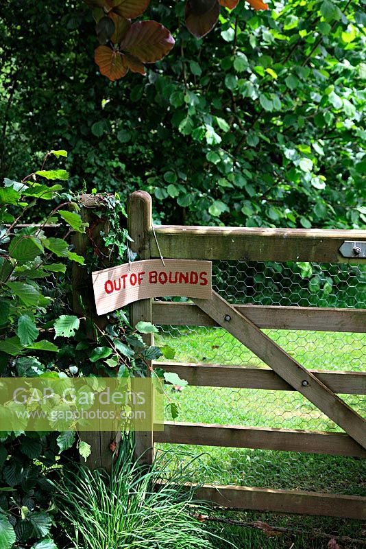 Out of bounds sign hanging on wooden gate