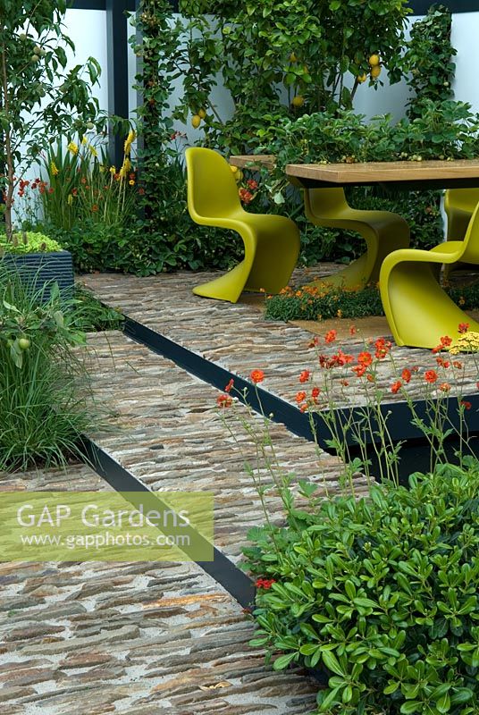 Contemporary dining table and seating in courtyard garden with surrounding planting of both local and Mediterranean plants and crops. 'Food 4 Thought' - Gold Medal Winner - RHS Hampton Court Flower Show 2010 