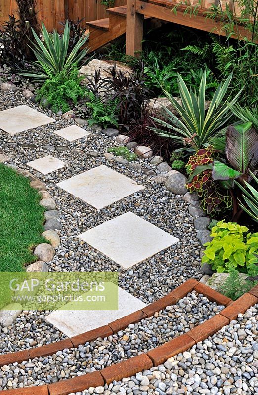 Slab stepping stones in gravel path, edged with large pebbles - RHS Tatton Park Flower show 2010