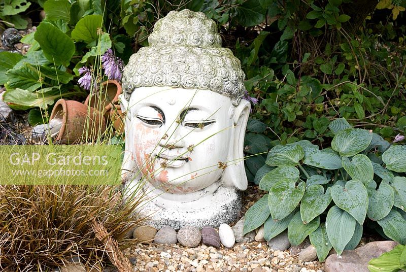 Buddha head garden statue at Meadow Ave, Southport, Lancashire. The garden opens for The National Gardens Scheme