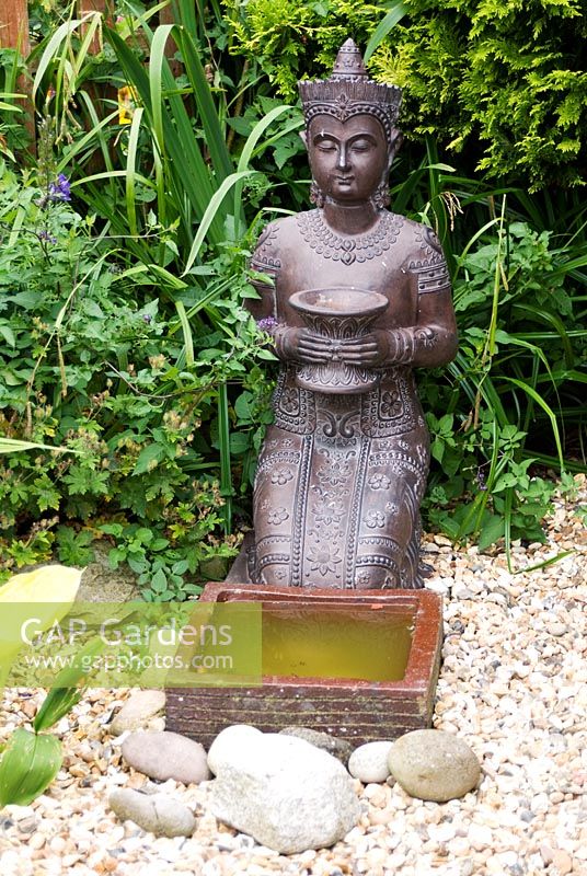 Kneeling Thai Statue at Meadow Ave, Southport, Lancashire. The garden opens for The National Gardens Scheme