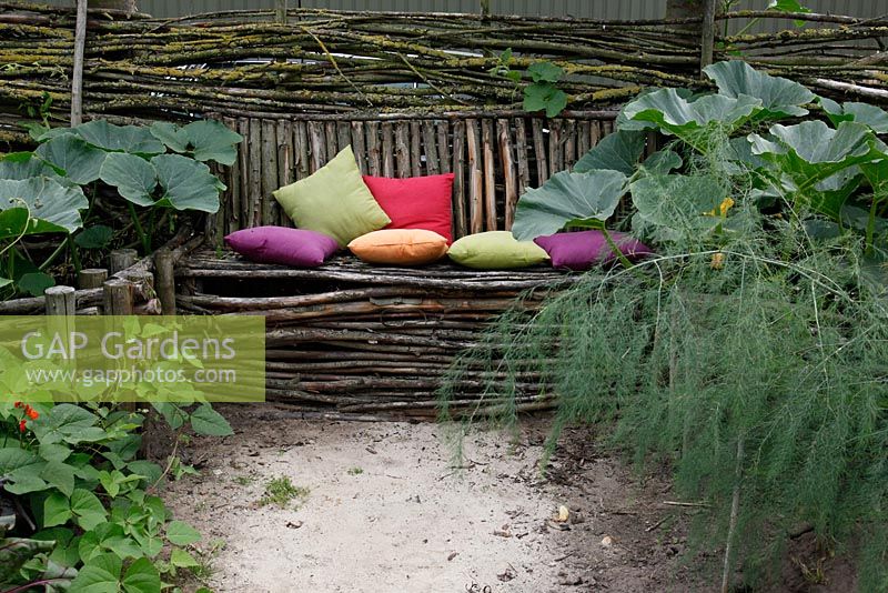 Rustic bench with colourful cushions in Dutch garden and tearoom - De Tuinen in Demen