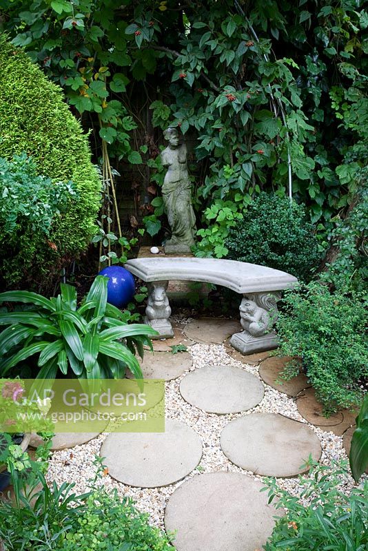 Statue and bench with round paving stones. Nina and Fred Preston's garden
 