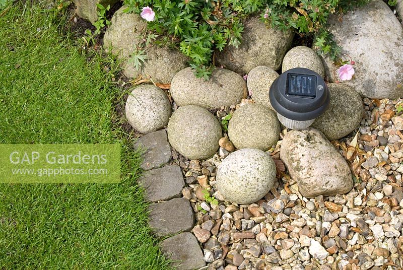 Solar powered garden light in cobble and gravel bed edged by stone setts - 'Trevinia', Stubbins, Lancashire, NGS