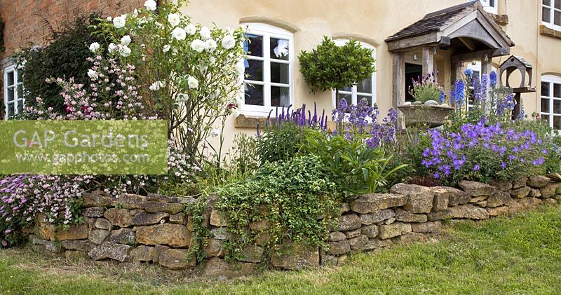 Stone retaining wall with blue and white themed plantings - Ilmington, Warwickshire