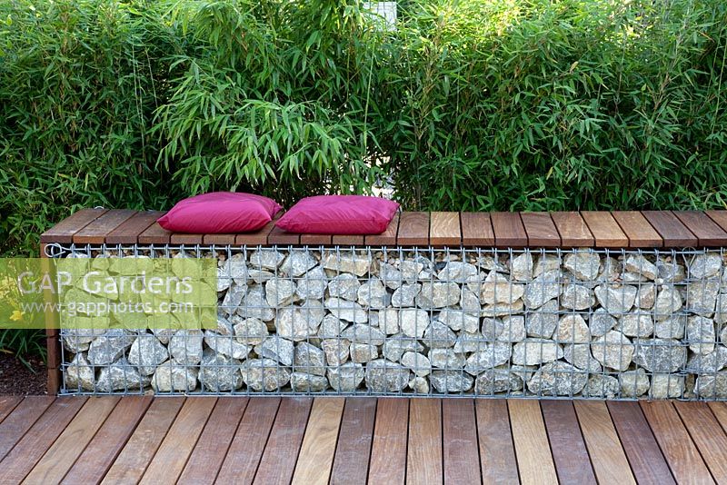 Bench made from wood and gabions backed by Fargesia murielae - Bamboo hedge