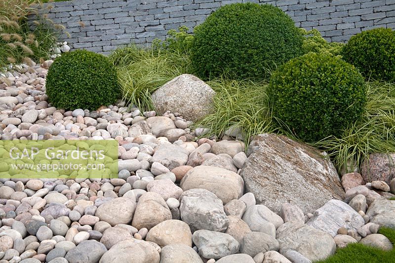 'Wave Dance' pebble beach garden with clipped topiary balls and grasses at RHS Tatton Park 2010
