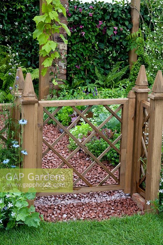 Wooden gate and border of Alchemilla and Nigella beyond. The Mod-ieval Garden - RHS Tatton Park 2010