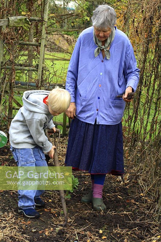 Leonie Woolhouse in the vegetable garden with her grandson, Arthur, learning how to dig - The Old Sun House, Wymondham, Norfolk, NGS 