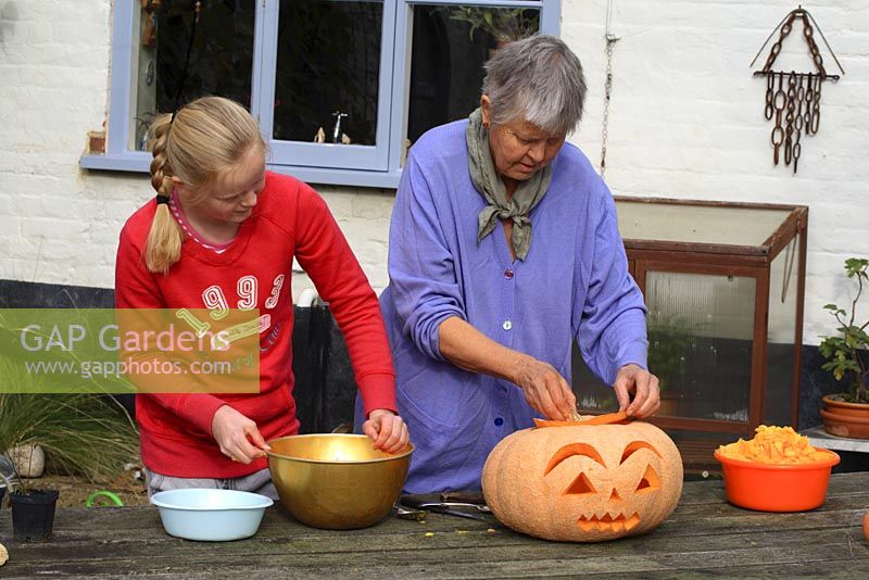 Leonie Woolhouse carving a pumpkin for Halloween with her grandaughter, Tabitha - The Old Sun House, Wymondham, Norfolk, NGS 