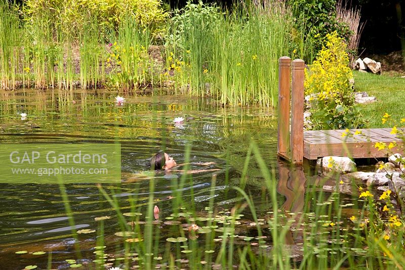 Young girl swimming in the swimming zone of a natural swimming pool