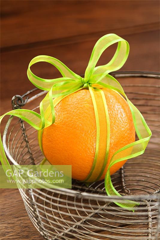 Orange decorated with brightly coloured ribbon for Christmas