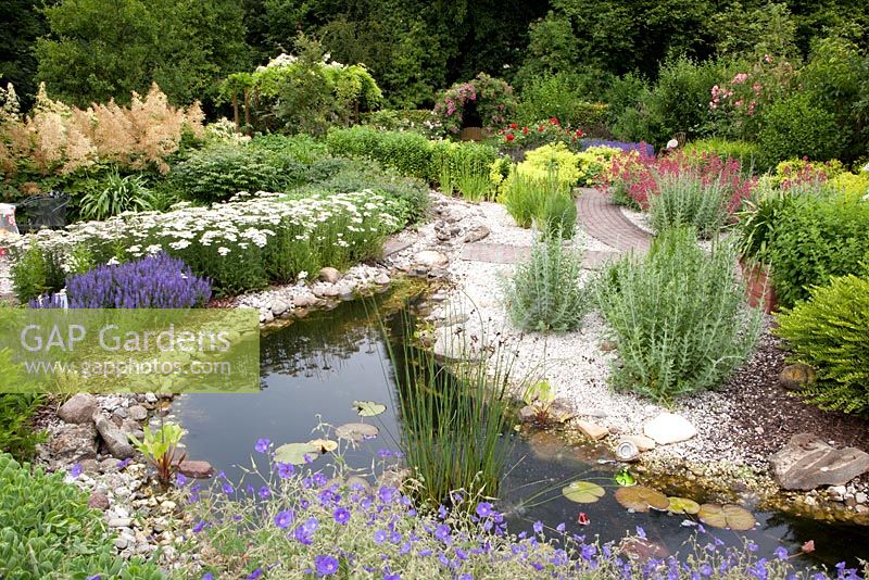 Pond with planting of Salvia nemorosa, Achillea and Geranium 'Spinners'
