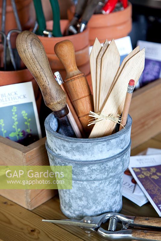 Wooden plant labels and tools in metal pot