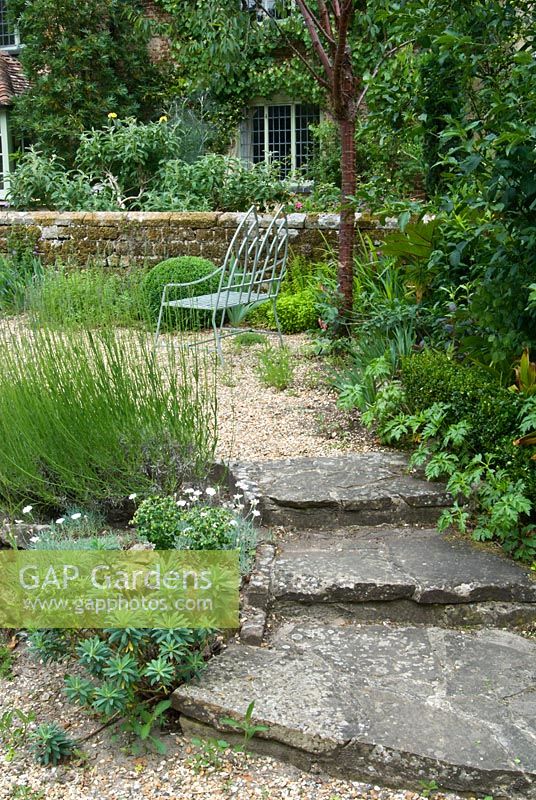 Front garden with stone steps, gravel path and seat. Sandhill Farm House, Hampshire.