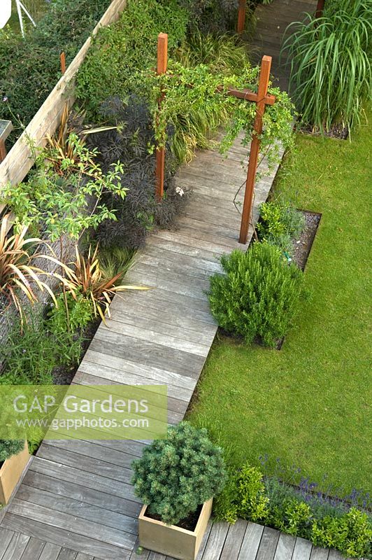 Small urban garden with wooden deck path and containers - Highgate, London
