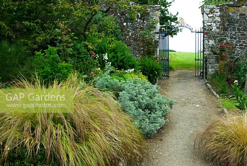 Gateway in walled garden leads onto grassy lawns around the house, with views up the coast and across to Lundy Island. Clovelly Court, Bideford, Devon, UK