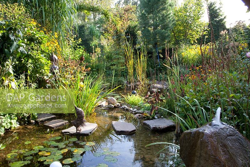 Pod in autumn with stepping stones and fountain spout in rock