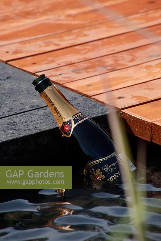 Bottle of champagne in pool of contemporary garden. BLOOM flowershow 2010 Dublin, Ireland.