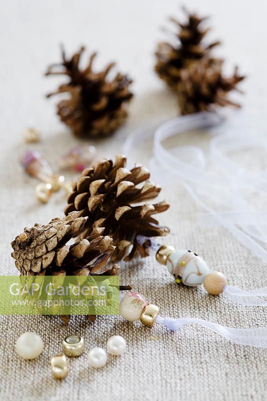 Making pine cone decorations with beads - STEP 6.  Thread beads on to the ribbons