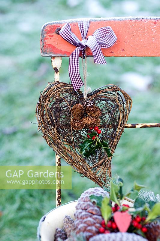 Heart wreath with Ilex - Holly sprigs, tied to red chair