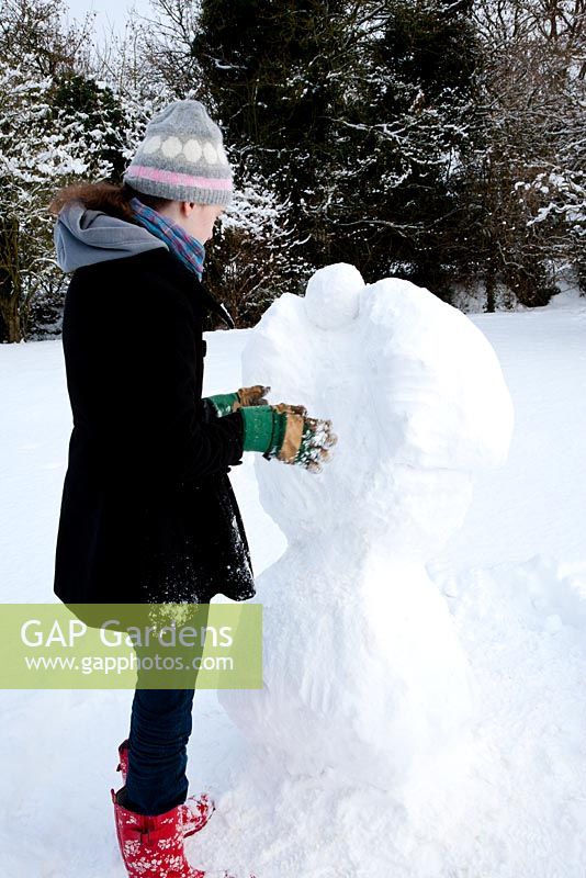 Teenage girl building snow angel