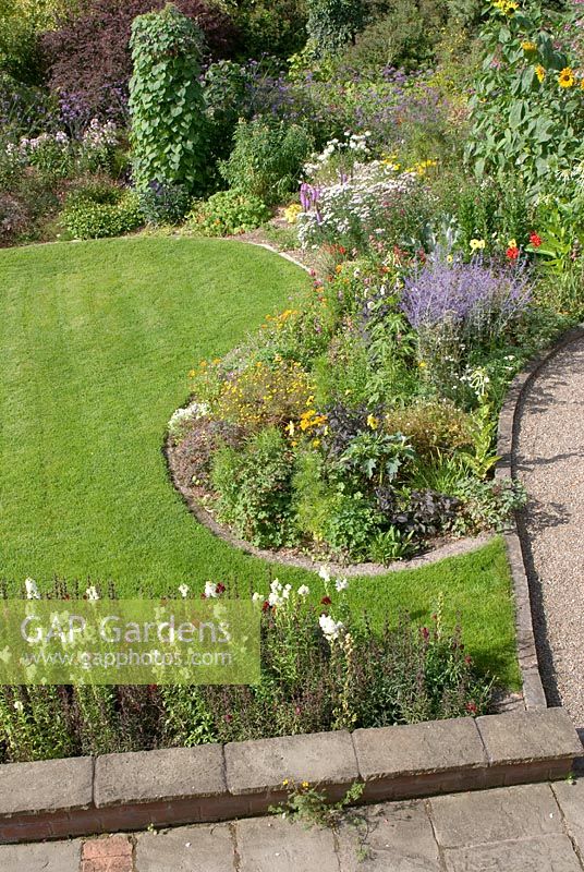 Elevated view of late summer mixed borders with adjacent patio, path and lawn at 'Springbank', Davenham, Cheshire NGS