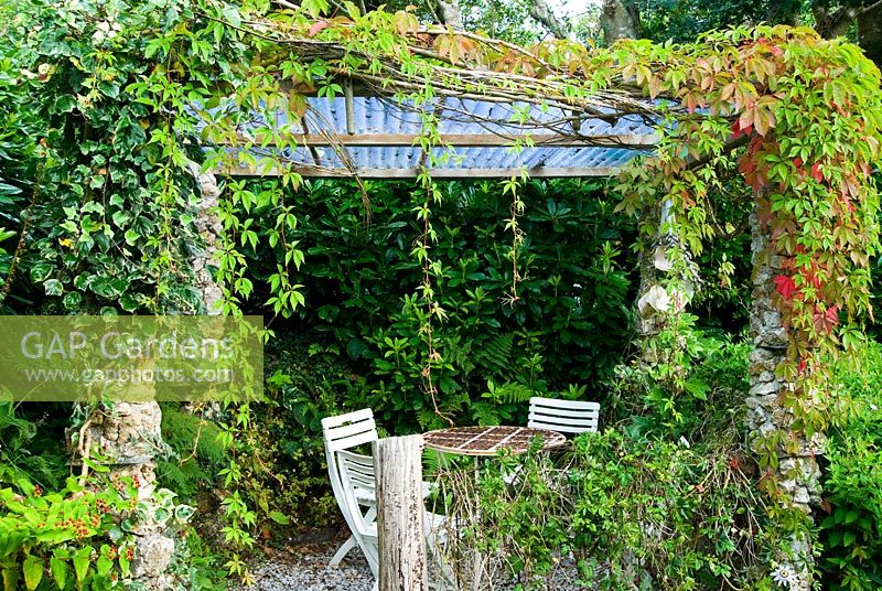 Tea shelter with columns constructed from white feldspar, supporting creeper and passion flower - Pinsla Garden, Cardinham, Cornwall