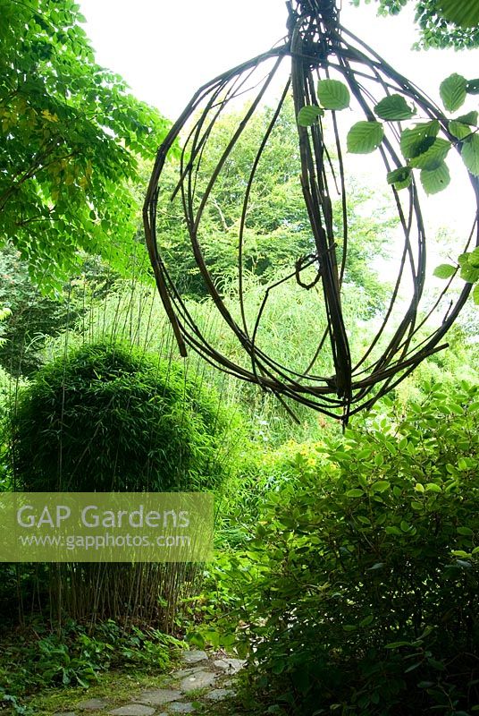 Suspended sphere of bamboo and metal chain - Pinsla Garden, Cardinham, Cornwall, UK