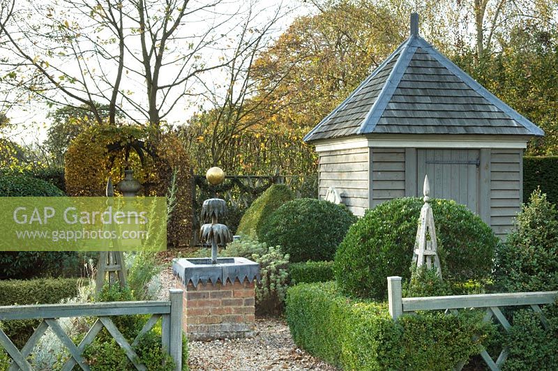 Water fountain, topiary and wooden building - Silverstone Farm, Norfolk