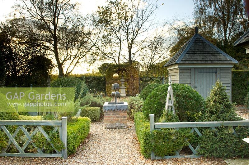 Buxus - Box parterre with water feature, wooden shed and topiary. Silverstone Farm, Norfolk, October