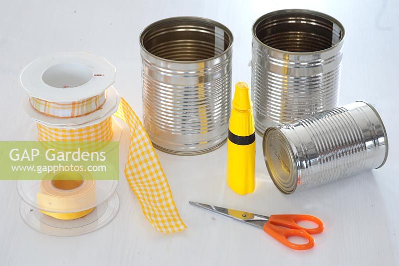 Decorating tin cans with yellow and orange ribbon. Step 1 of 3. Ingredients - clean tin cans, ribbons, scissors and glue
