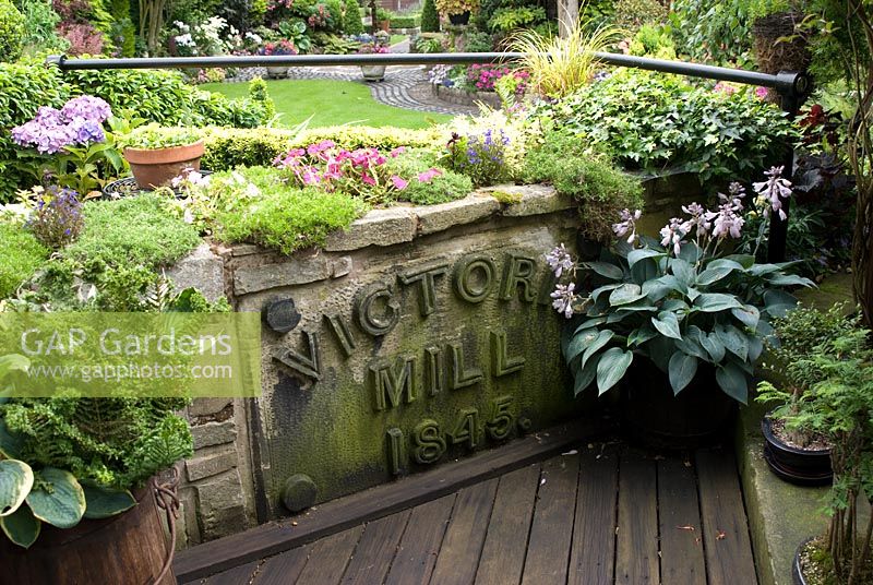 Hosta 'Halcyon', fern and alpines by reclaimed mill sign and decking from Southport pier planks - Brocklebank Road, Southport, Lancashire NGS 
