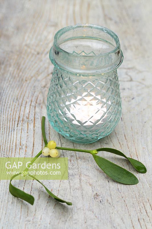 Glass candle holder and sprig of mistletoe 
