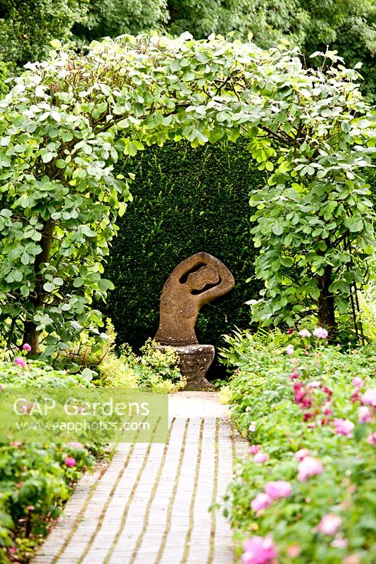The Rose Border leading to a sculpture - Kiftsgate Court Garden, Chipping Campden, Gloucestershire, UK