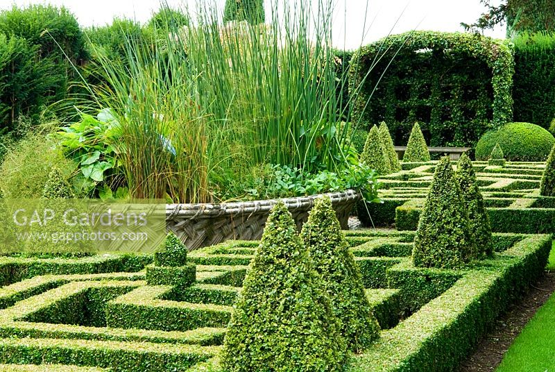 Geometric knot garden of Buxus - Box framed within Taxus - Yew walls, with central basket pond from the Great Exhibition of 1851. Bourton House, Bourton-on-the-Hill, Moreton-in-Marsh, Glos, UK