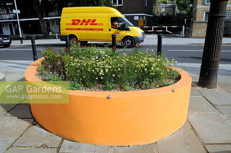 Colourful yellow gold street planter with matching plants, Holloway, London Borough of Islington.