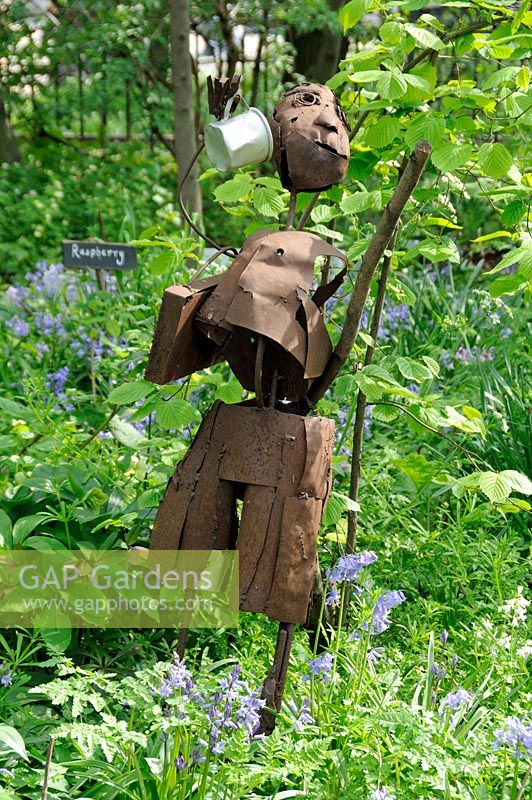 Decorative sculpture of a male figure made of recycled scrap metal in the garden at Hackney City Farm London UK