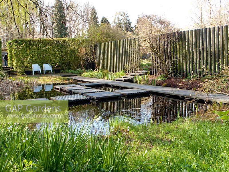 Natural wildlife pond with decked stepping stones. Mien Ruys Tuinen, Dedemsvaart, Netherlands 